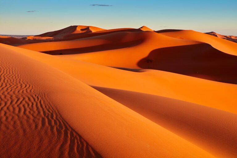 Impresionante vista del desierto de Merzouga al atardecer con dunas doradas, ideal para excursiones Merzouga.